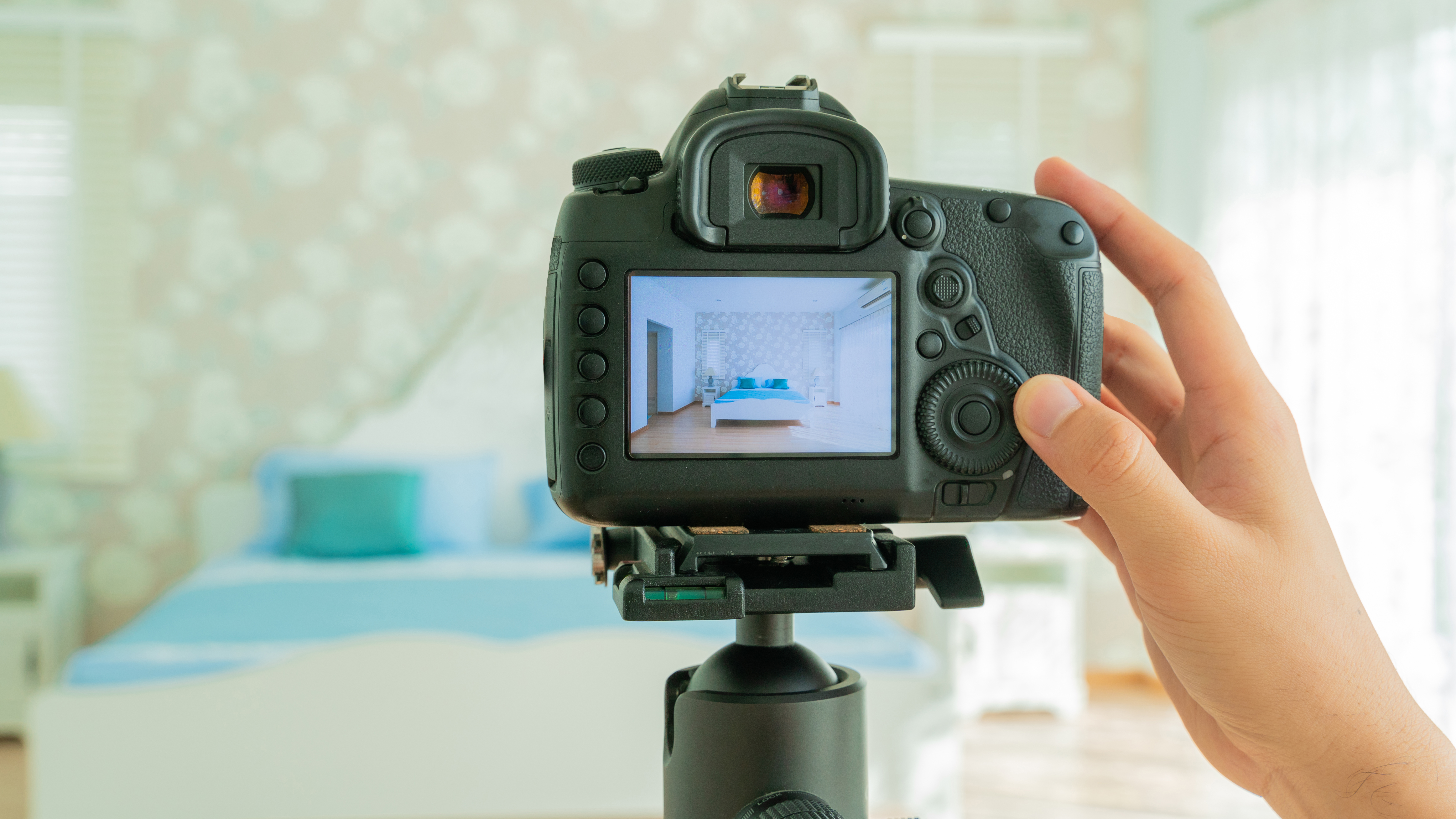 Een fotograaf maakt professionele beelden van een slaapkamer, als voorbeeld van hoe goede vastgoedfoto’s verkoopfouten helpen vermijden