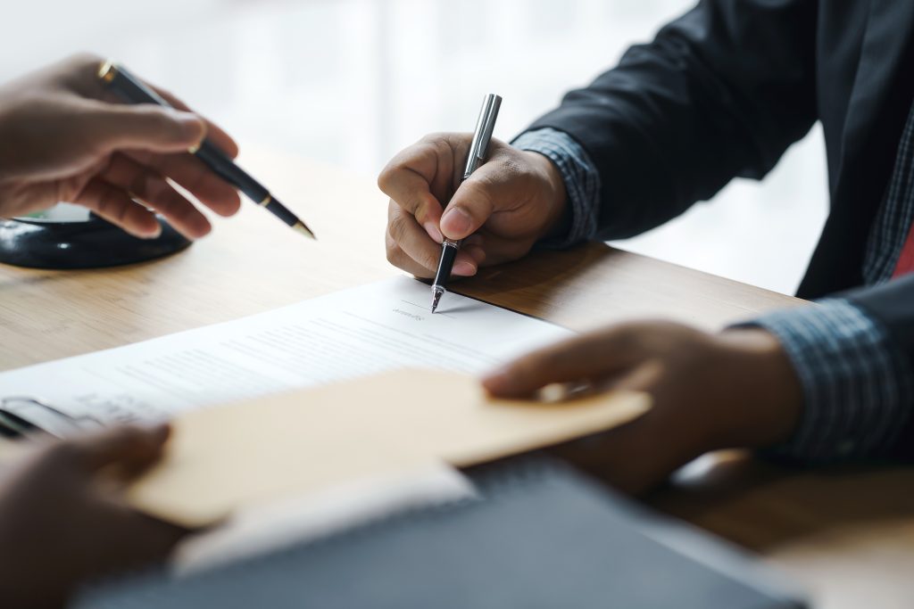 Het ondertekenen van de aankoopakte, waarbij registratierechten worden betaald aan de overheid.