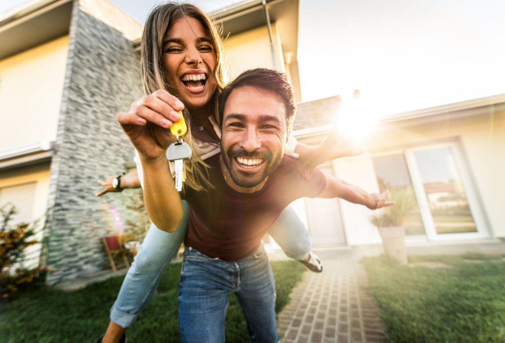 Een gelukkig koppel dat de sleutels van hun nieuwe woning ontvangt