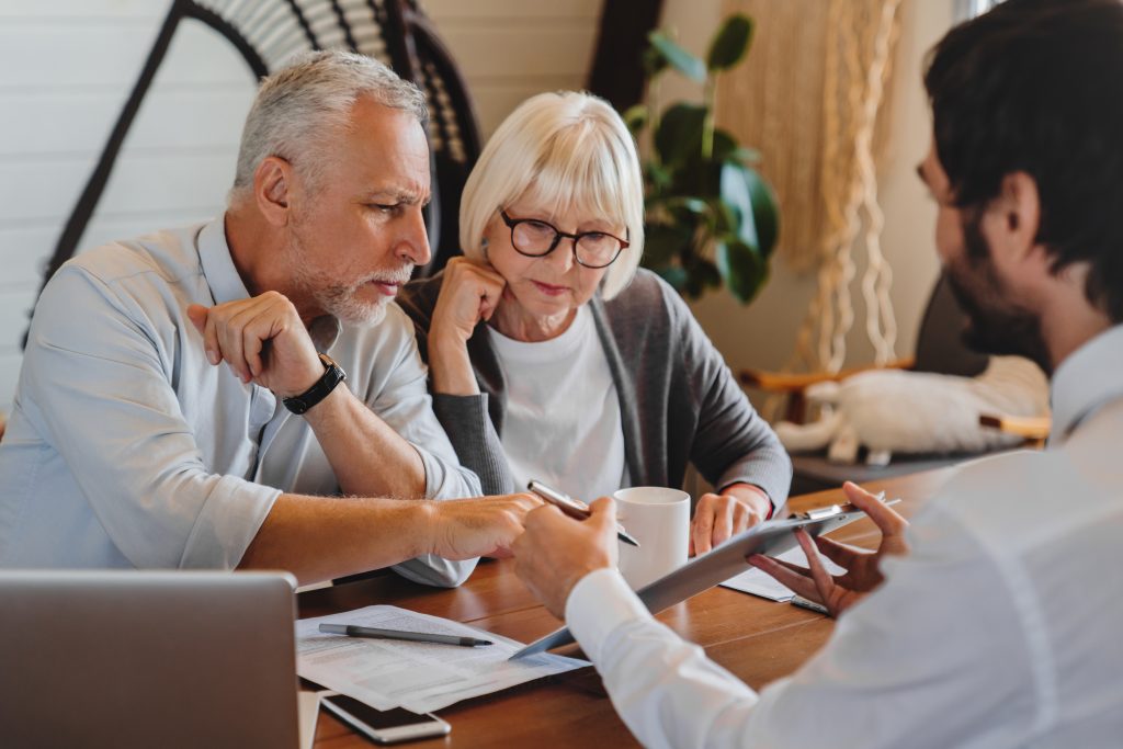 Een koppel bespreekt de notariskosten met een adviseur bij de aankoop van hun woning